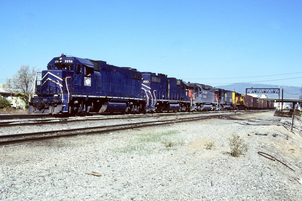 MP 2056 is a class EMD GP38-2 and  is pictured in Colton, California, USA.  This was taken along the Los Angeles/SF on the Missouri Pacific Railroad. Photo Copyright: Rick Doughty uploaded to Railroad Gallery on 01/30/2024. This photograph of MP 2056 was taken on Saturday, November 30, 1985. All Rights Reserved. 