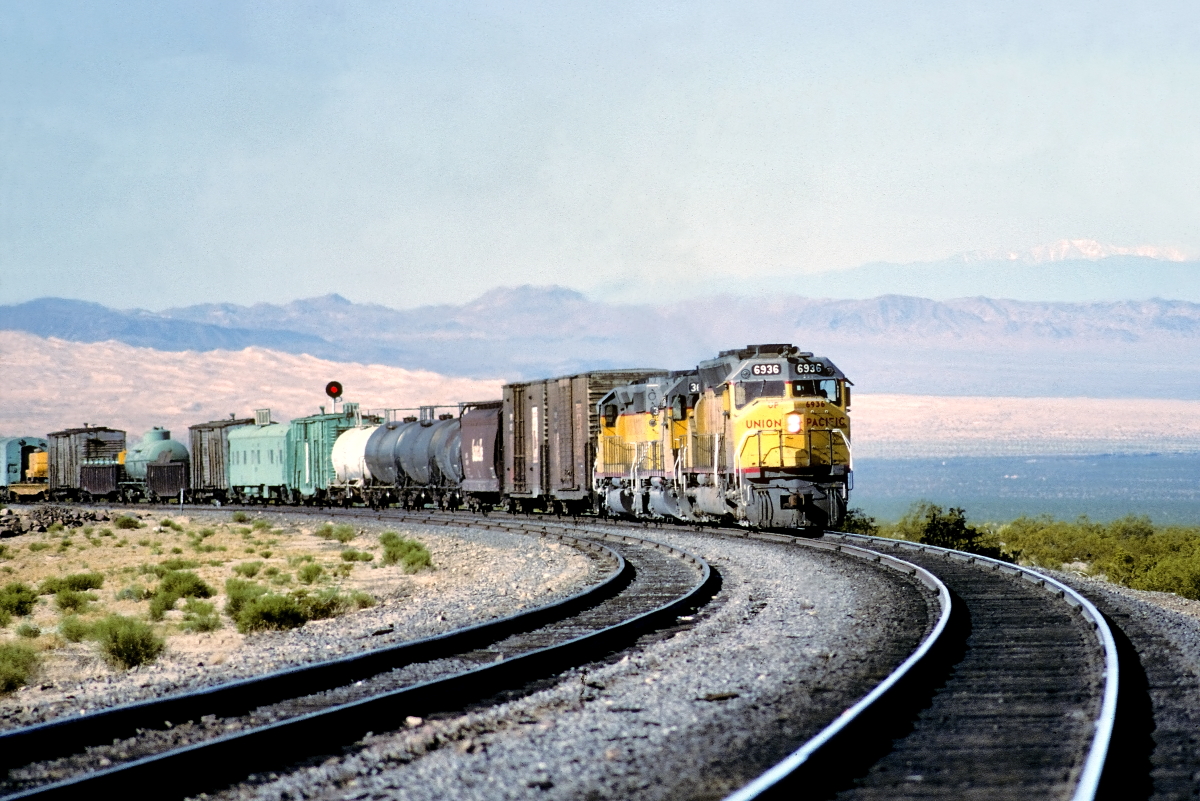 UP 6936 is a class EMD DD40X and  is pictured in Kelso, California, USA.  This was taken along the Cima/UP on the Union Pacific Railroad. Photo Copyright: Rick Doughty uploaded to Railroad Gallery on 07/18/2024. This photograph of UP 6936 was taken on Friday, April 20, 1984. All Rights Reserved. 