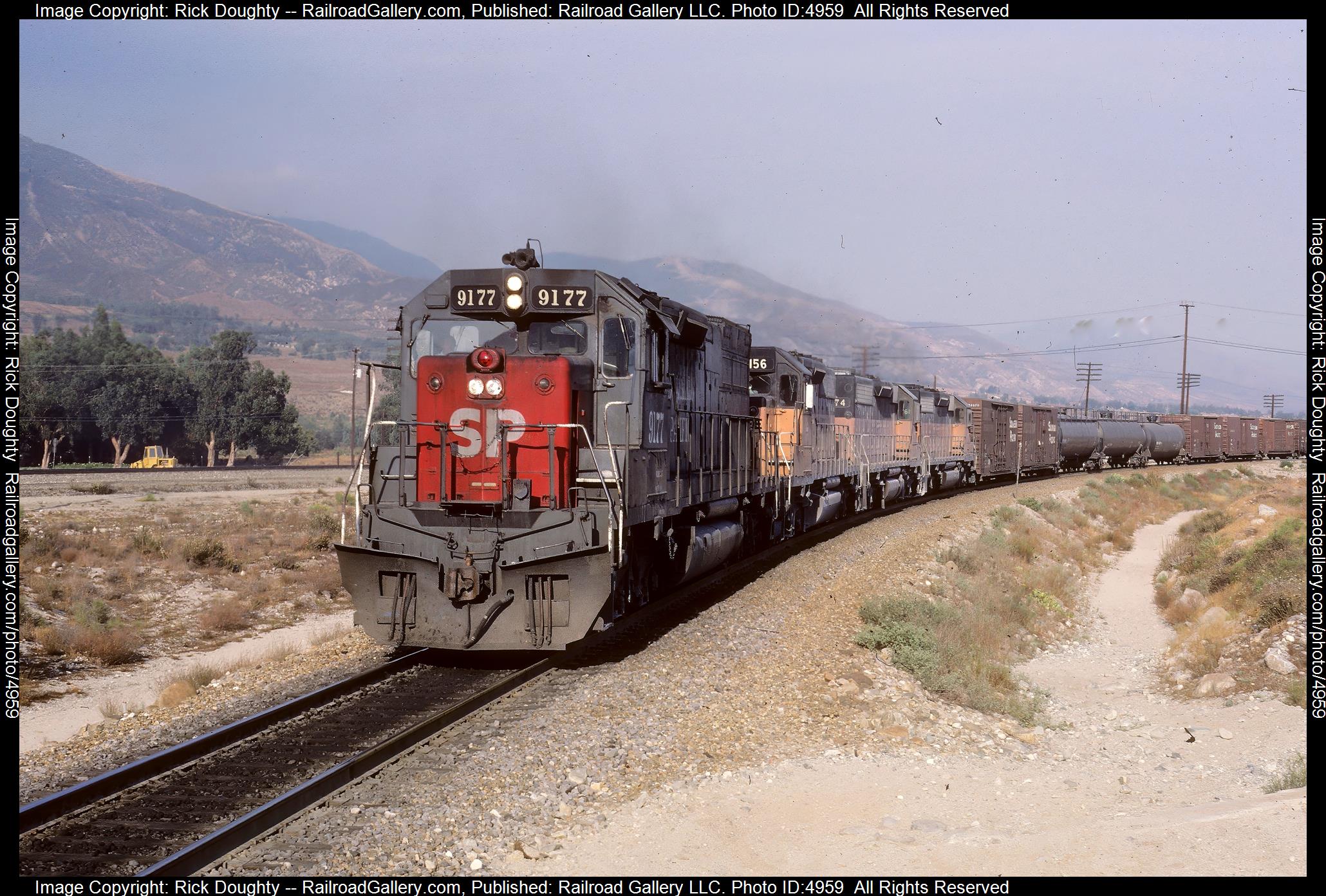 SP 9177 is a class EMD SD45T-2 and  is pictured in Devore, California, USA.  This was taken along the Mojave/SP on the Southern Pacific Transportation Company. Photo Copyright: Rick Doughty uploaded to Railroad Gallery on 12/16/2024. This photograph of SP 9177 was taken on Saturday, July 21, 1984. All Rights Reserved. 